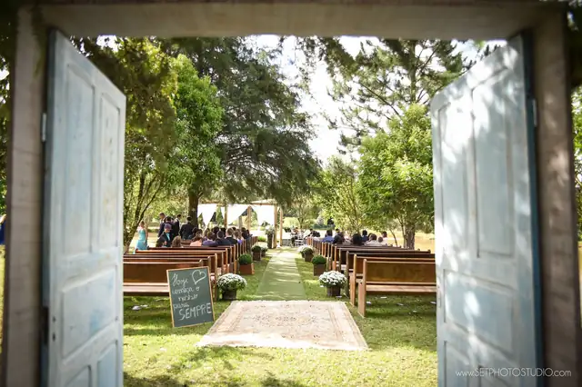 Cerimônia ao ar livre vista pelo portal decorativo da Lagoa Eventos