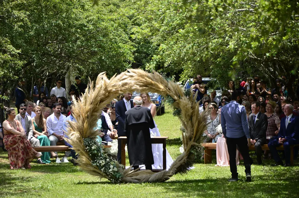 Cerimônia ao ar livre com arco de capim dourado na Lagoa Eventos